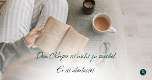 Person hält Buch in der Hand (Perspektive von oben fotografiert), daneben stehen eine Kerze, eine Tasse Tee und eine Brille Text im Bild: Dein Körper ist nicht zu sensibel. Er ist überlastet.